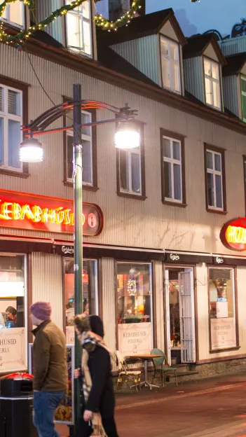 Neon sign on building in street of Reykjavik at night.