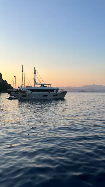 Boats on the water in Turkey at dusk as the sun sets on the horizon.