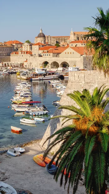 Old Town harbour of Dubrovnik with stone buildings and orange tiled rooves.
