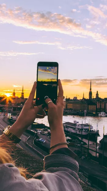A phone capturing a photo of the Stockholm sunset during sunset.