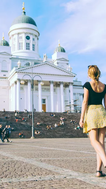 Person walking towards the steps of the Helsinki Cathedral.