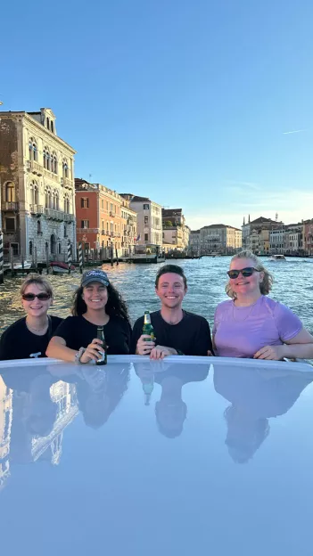 Topdeck travelers having a drink on a cruise through the canals of Venice.