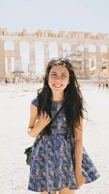 Person standing in front of the Acropolis of Athens.