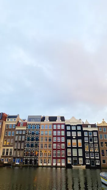Canal houses along the canal in Amsterdam painted in various colours.
