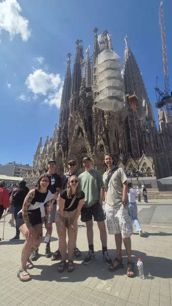  Small group of people pose in front of the Sagrada Família in Barcelona.