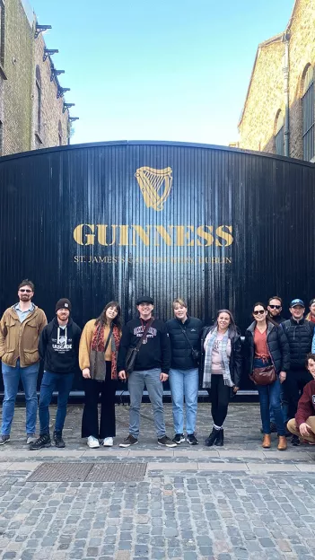 People posing together in front of the Guinness Storehouse’s gate in Dublin.