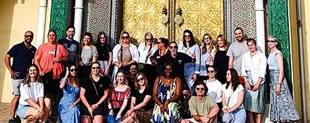 Topdeck Group tour led by tour leader Mike posing for a group photo in front of a Cathedral door.