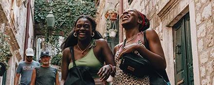 Topdeck travelers sharing a laugh while walking through Croatian streets.