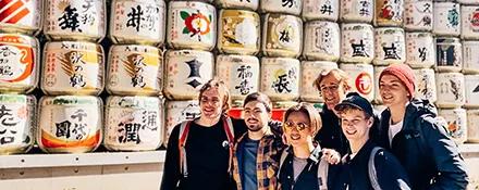 Topdeck Travellers posing in front of the Sake barrels at the Meiji shrine.