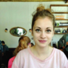 Woman wearing a pink top and hair pulled back into a bun
