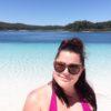 Woman with dark brown hair smiling on the beach