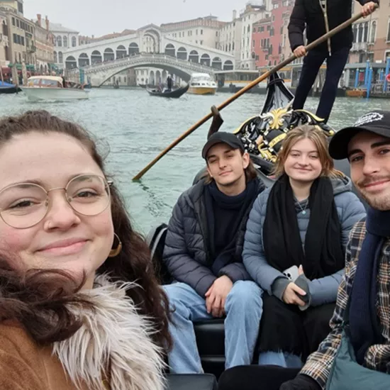 A Topdeck tour group taking a selfie together during their gondola ride through the Venice canals.
