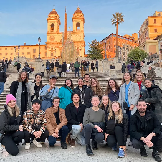 Topdeck travellers pose for a group photo in front of the iconic Trinità dei Monti in Rome.