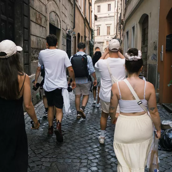 Group of people talking down a street in Rome together.