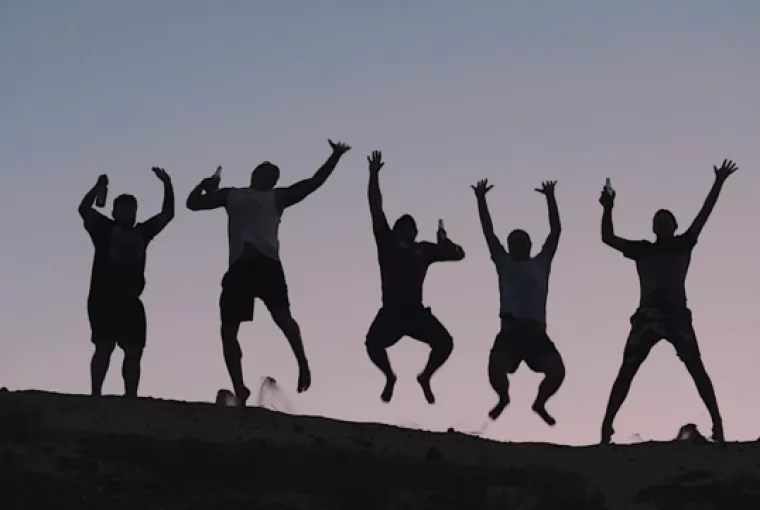 Group of Topdeck travelers jumping in celebration in the Egyptian desert.